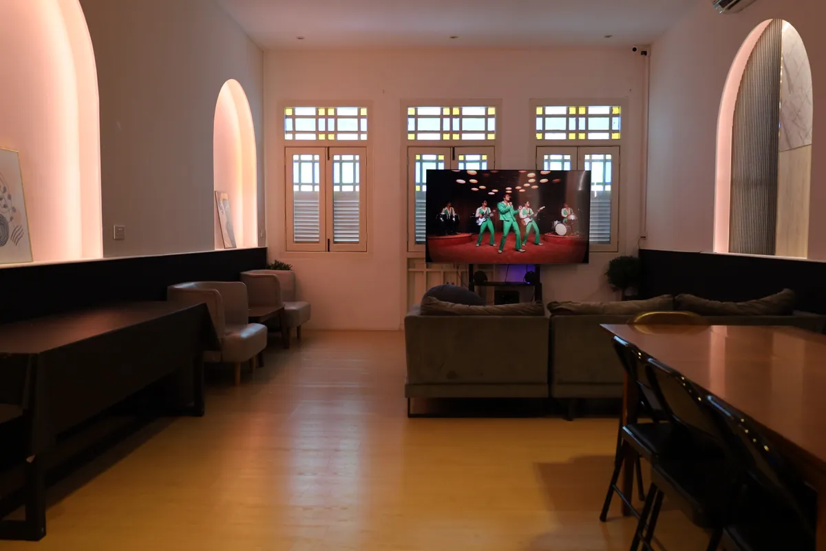 The Loft at 42 Foch Road: arched windows, lounge seating and a large screen